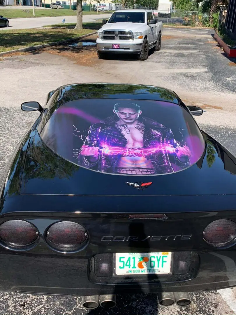 A picture of Jared Leto as the joker on a car