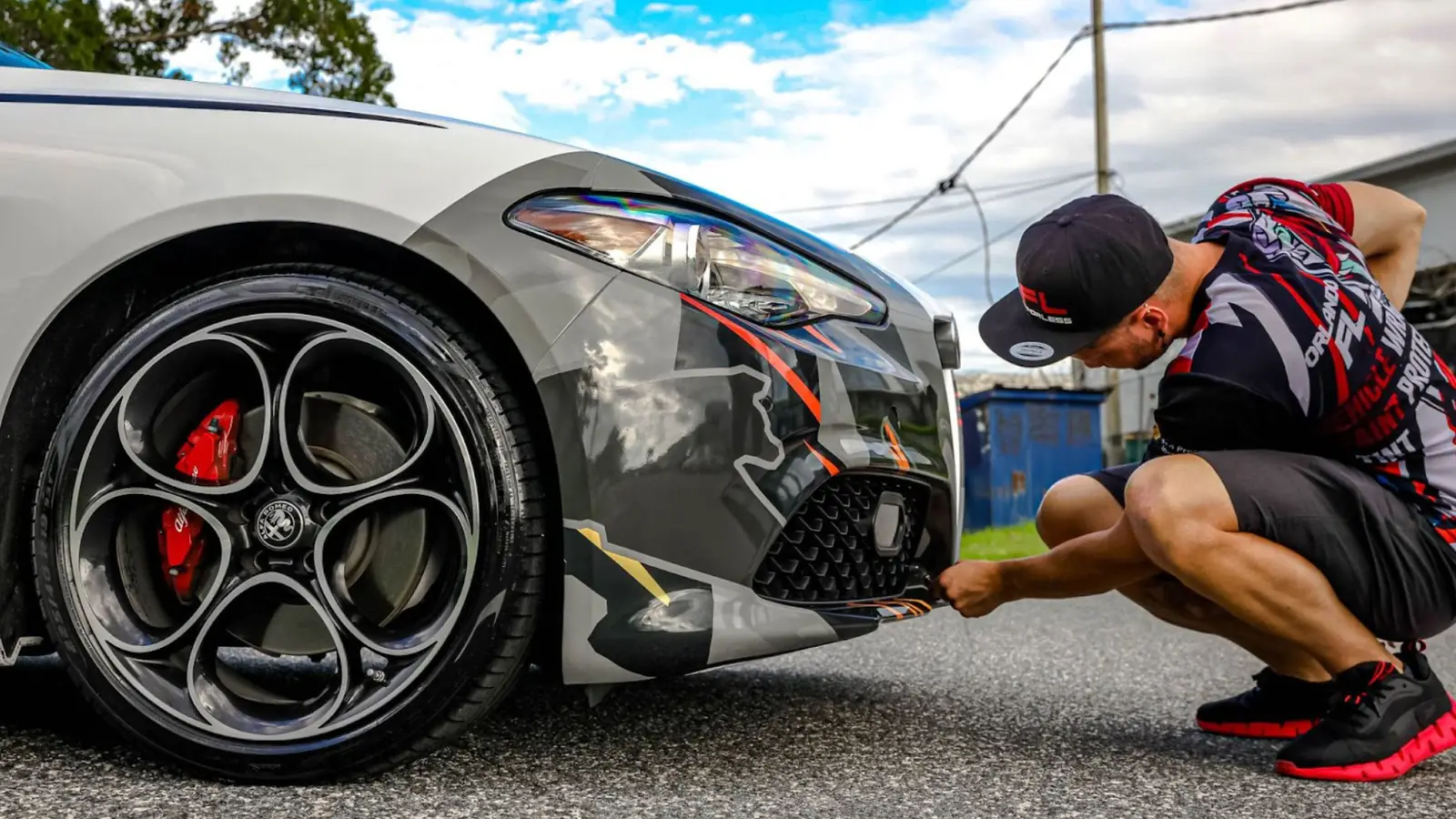 Installer checking the vinyl wrap on an Alfa Romeo front bumper