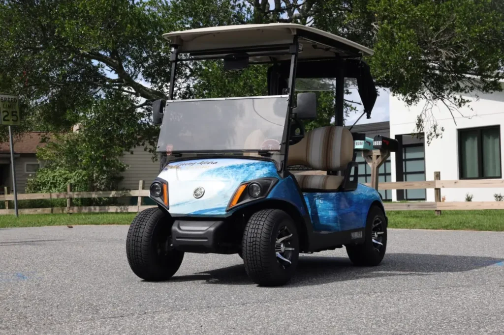 Golf cart with a custom blue wave graphic wrap