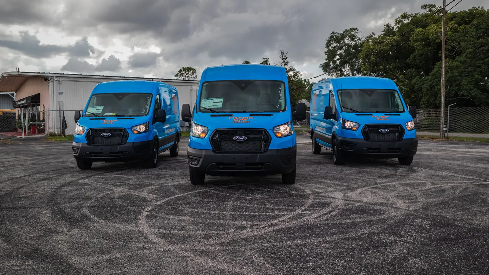 Fleet of three Ford Transit vans with blue company wraps