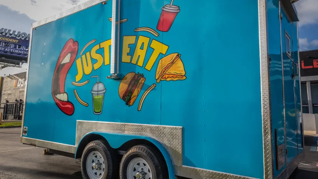 Blue food trailer wrap with Just Eat graphics