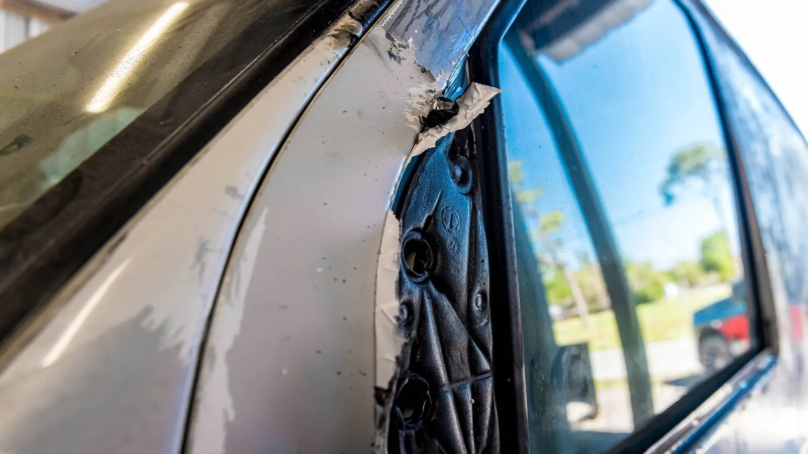 Old vinyl wrap peeling off a vehicle before removal