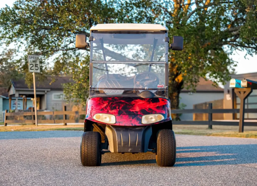 Front view of a golf cart with a red and black abstract wrap