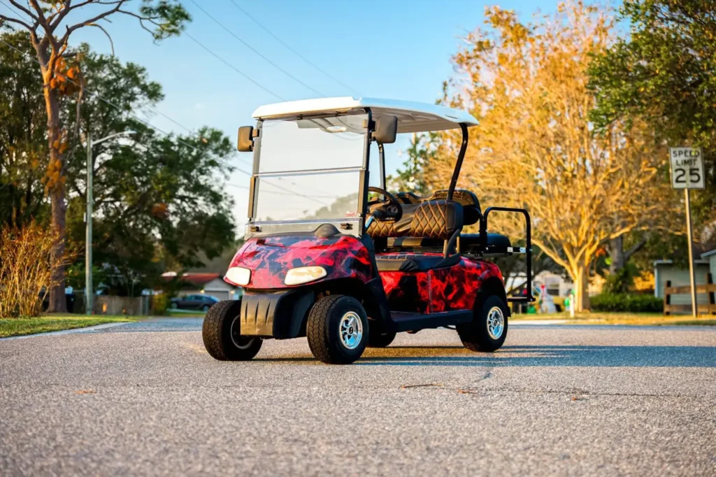 Red and black abstract golf cart wrap parked on a street