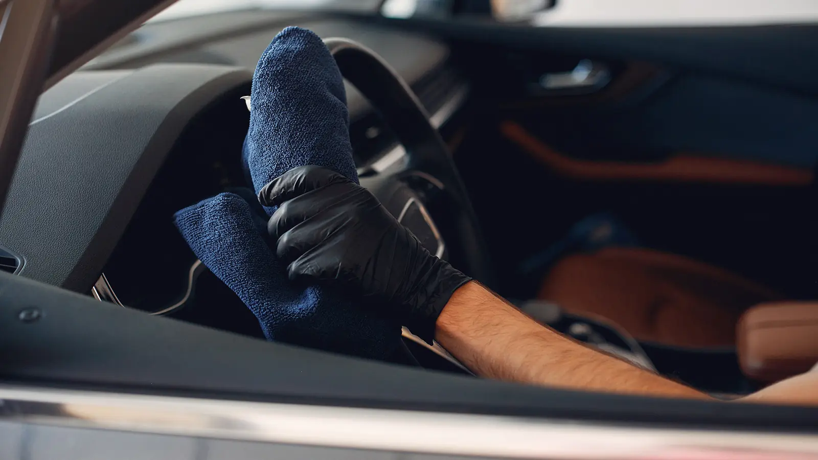 Technician wiping a car interior with a microfiber towel